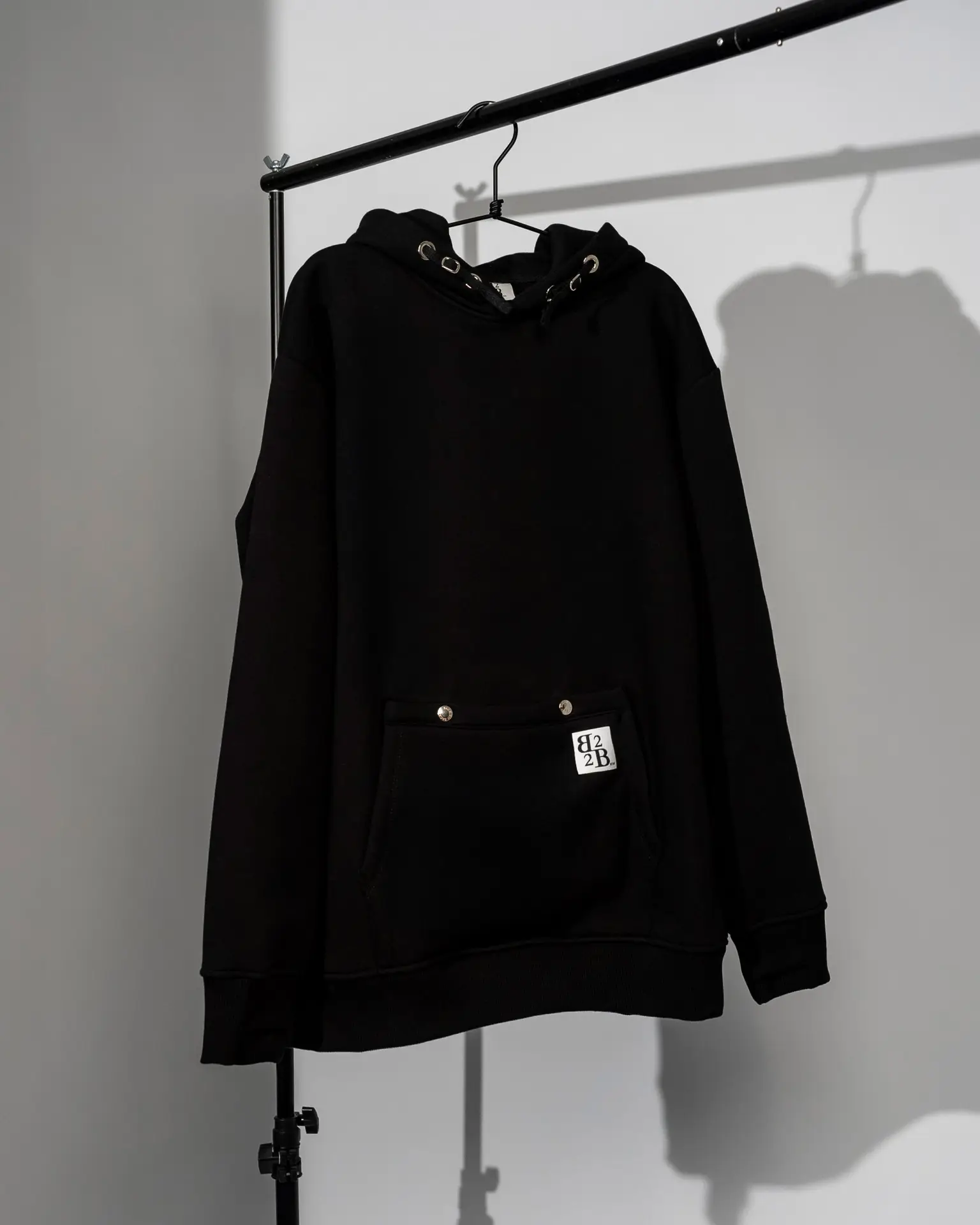 Felpa Nera a maniche lunghe, modello dritto con cappuccio e cordini regolabili a scorrimento con finiture metalliche e doppia tasca frontale B2B Ready To Wear